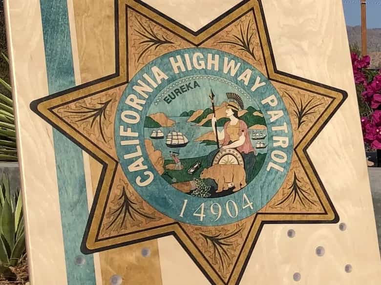 Close-up of a YoreBoard cornhole board with a hand-stained California Highway Patrol badge.