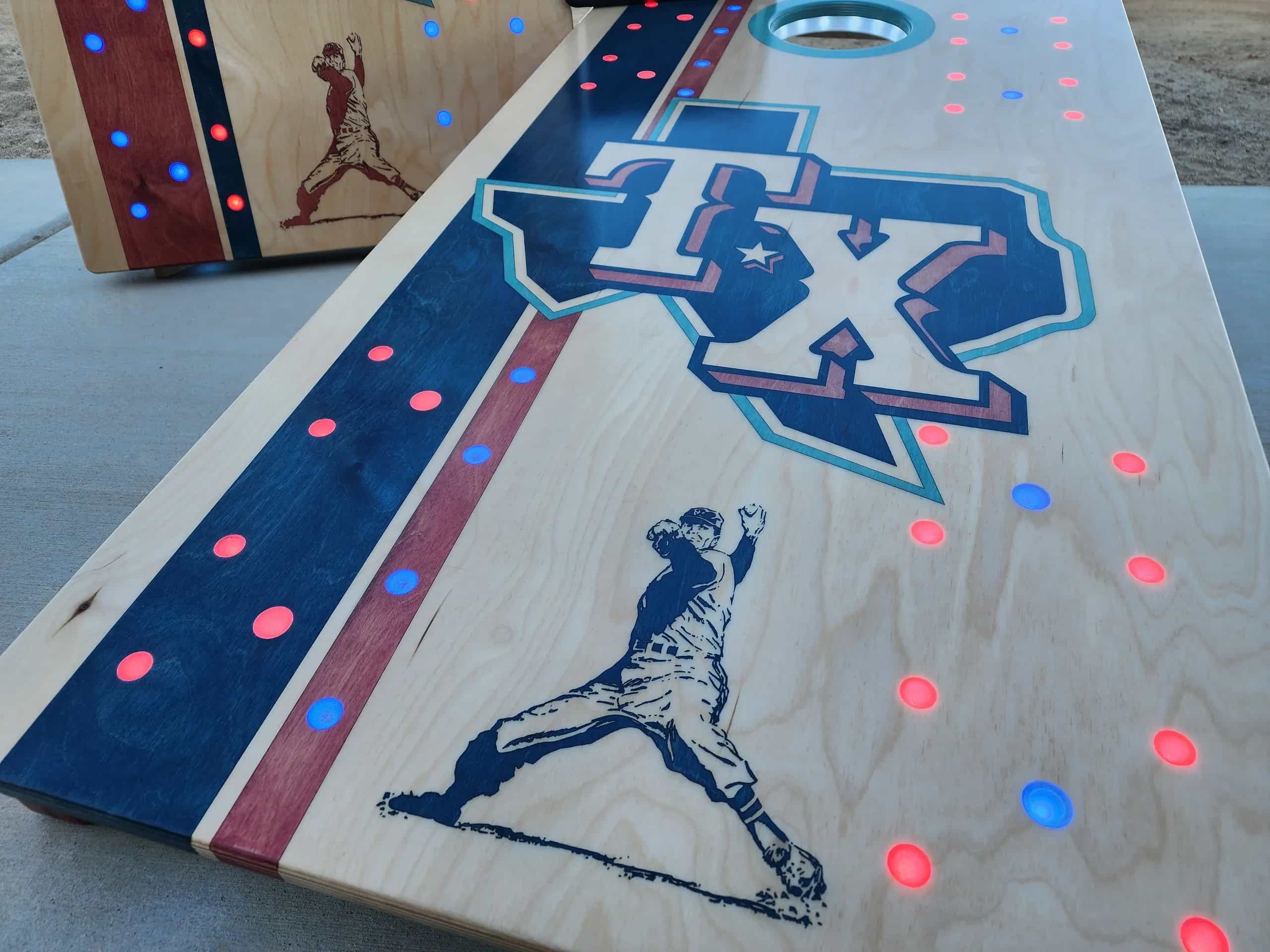 A close-up view of a YoreBoard cornhole board surface, showcasing a large, hand-stained Texas Rangers 'TX' logo and a baseball player silhouette.