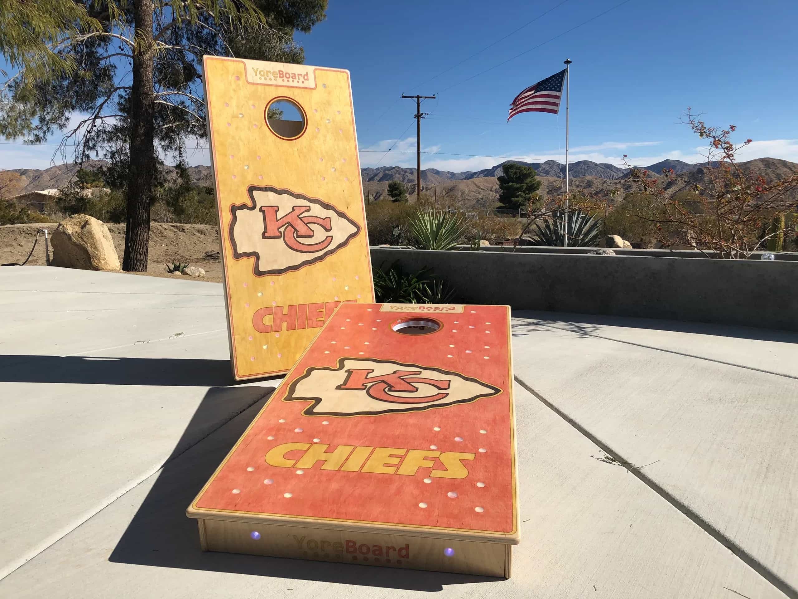 YoreBoard cornhole boards with vibrant, hand-stained team logos and integrated lighting, offering a premium and personalized experience for Chiefs fans.
