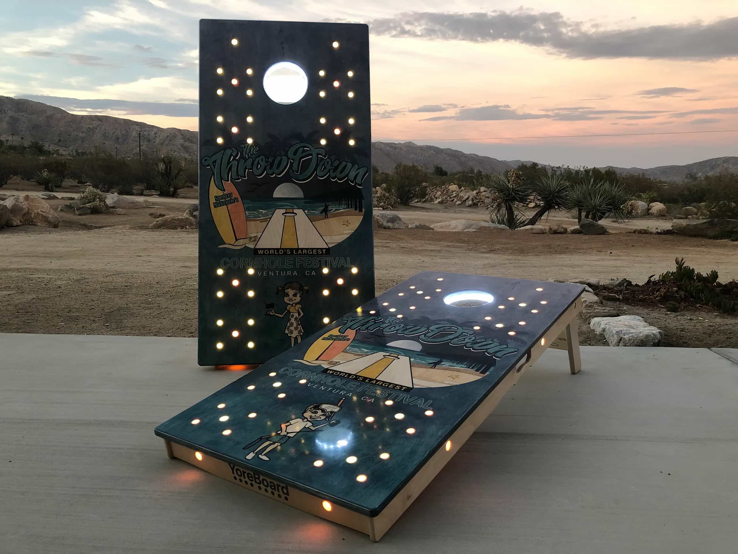 Custom 'The ThrowDown' YoreBoard cornhole set for World's Largest Cornhole Festival, Ventura, CA, with beach graphics and white and orange Scoring LEDs.