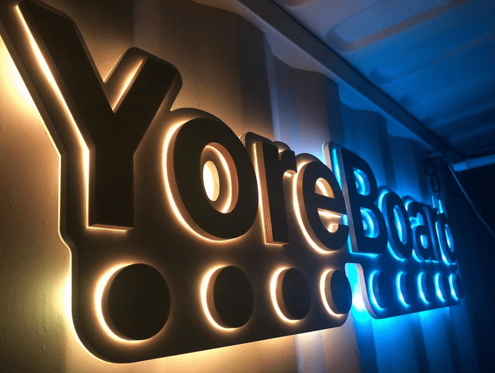 Vibrant 'YoreBoard' dimensional sign glowing with striking yellow and blue LED backlighting, creating a modern and eye-catching display.