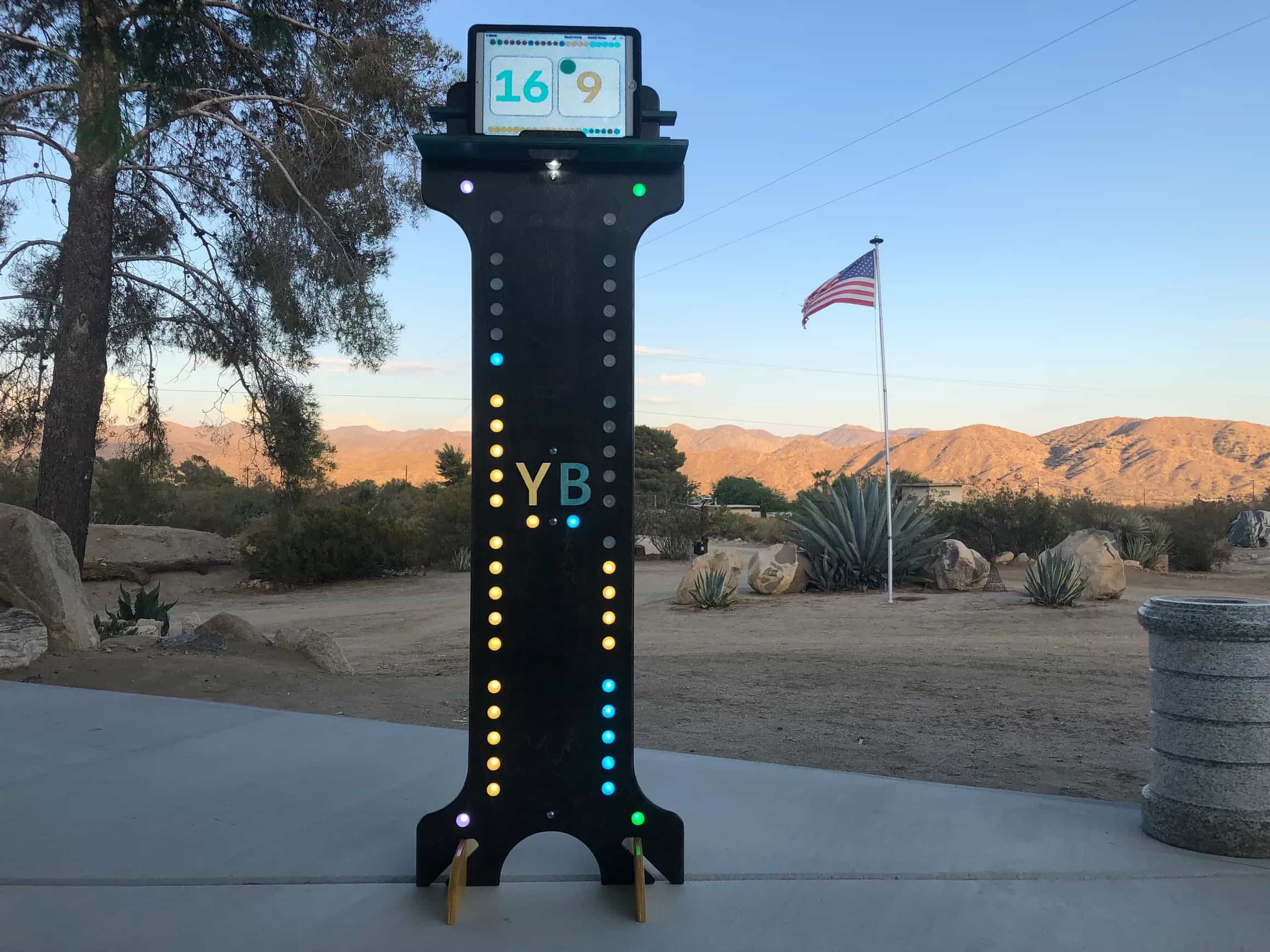 Brightly lit YoreBoard score tower featuring a tablet for digital scorekeeping and colorful Scoring LEDs, providing an enhanced and clear scoring experience.