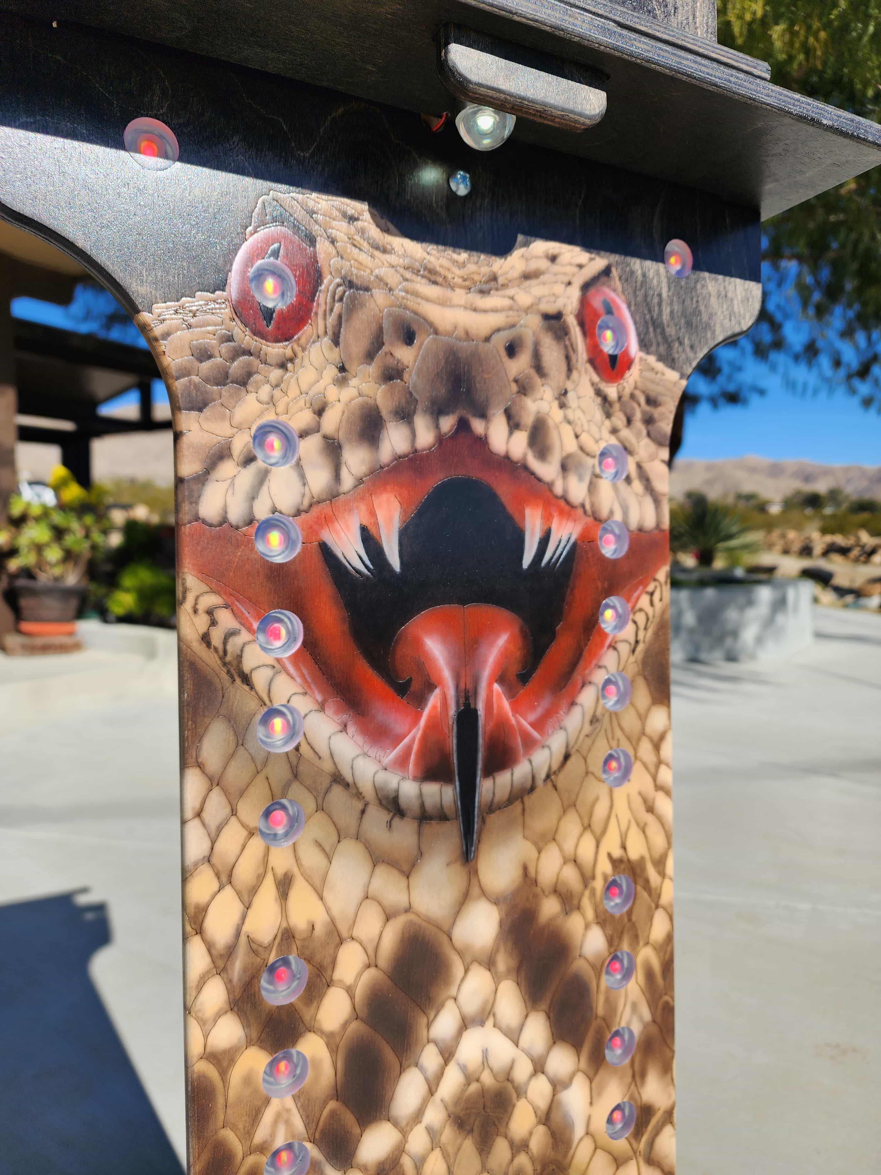 Detailed view of a YoreBoard score tower with a striking rattlesnake design, highlighting its scales, fangs, and the presence of Scoring LEDs.