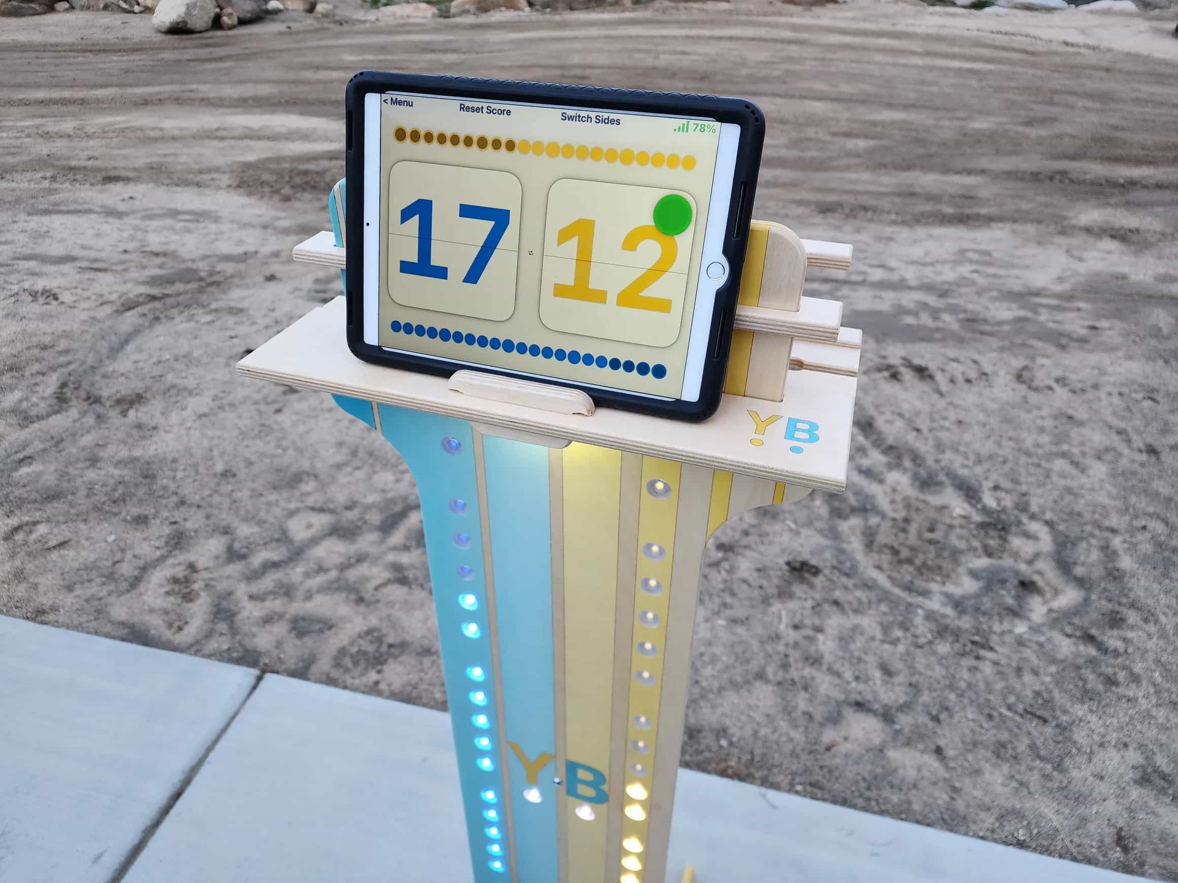 Close-up of YoreBoard score tower top displaying a digital scoreboard on a tablet and illuminated by yellow and blue Scoring LEDs.